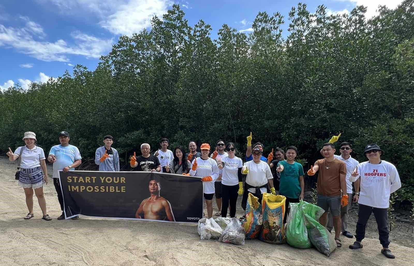 A group of people standing in front of a sign

Description automatically generated